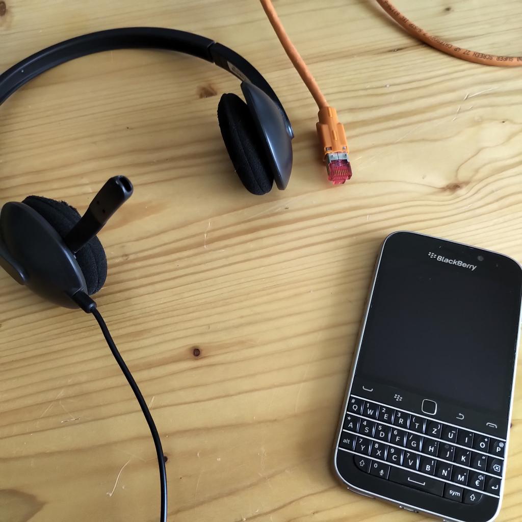 Titelbild mit einem Headset, einem Ethernetkabel und einem BlackBerry Classic.